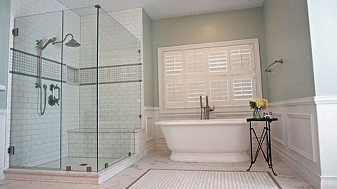 Master bathroom remodel with freestanding tub, glass shower, and plantation shutters